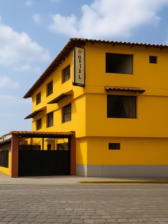 a yellow building with a black garage at San Sebastian Hostal in Sangolquí