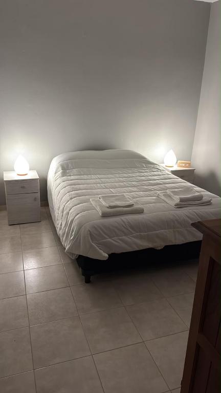 a bed in a bedroom with two lamps on top at Departamento Los Ceibos 2 in San Fernando del Valle de Catamarca