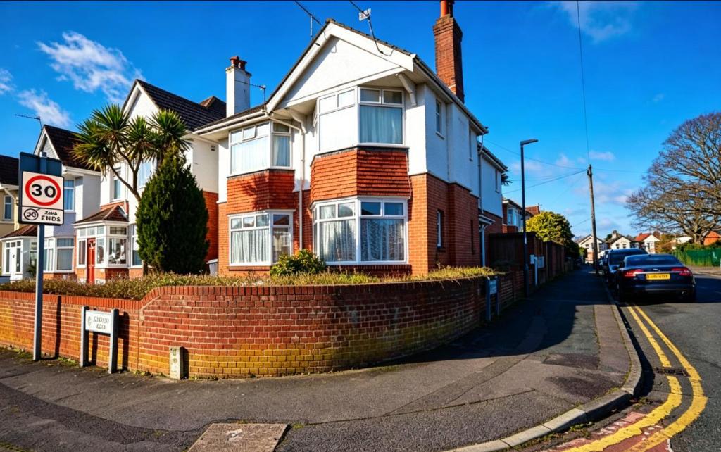 a house on a street with a brick wall at Winton house home stay in Bournemouth