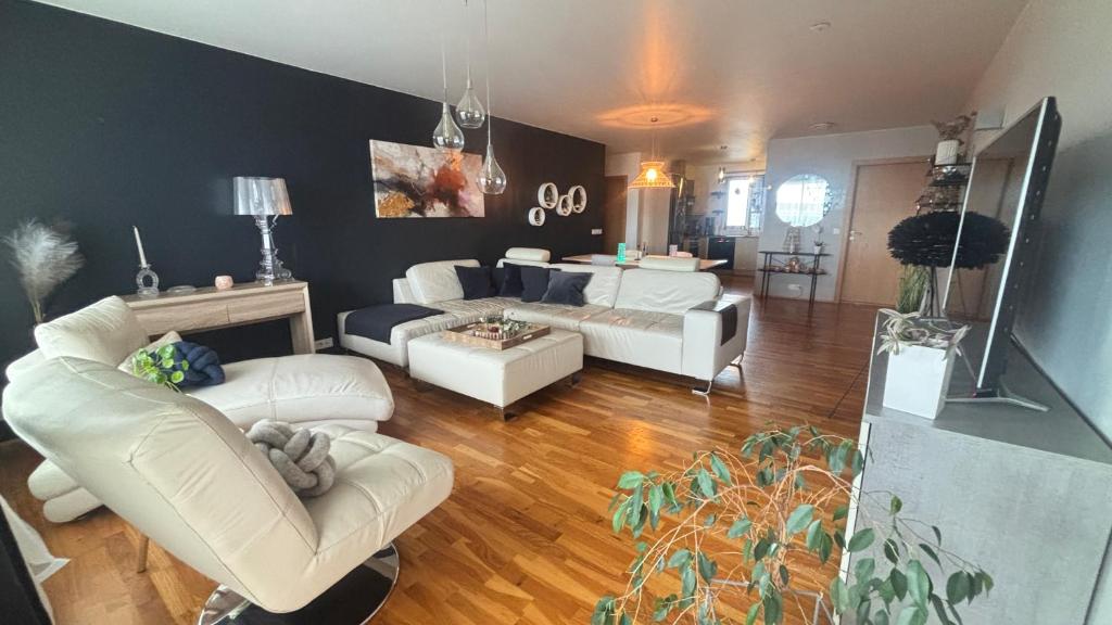 a living room with two white couches and a couch at Akranes Sunset Apartment in Akranes
