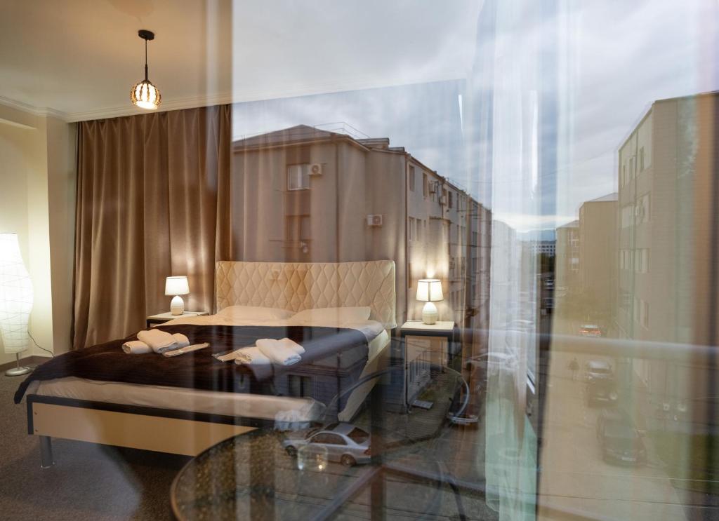 a room with a bed and a glass table at Chill Out Hotel Tskaltubo in Tsqaltubo