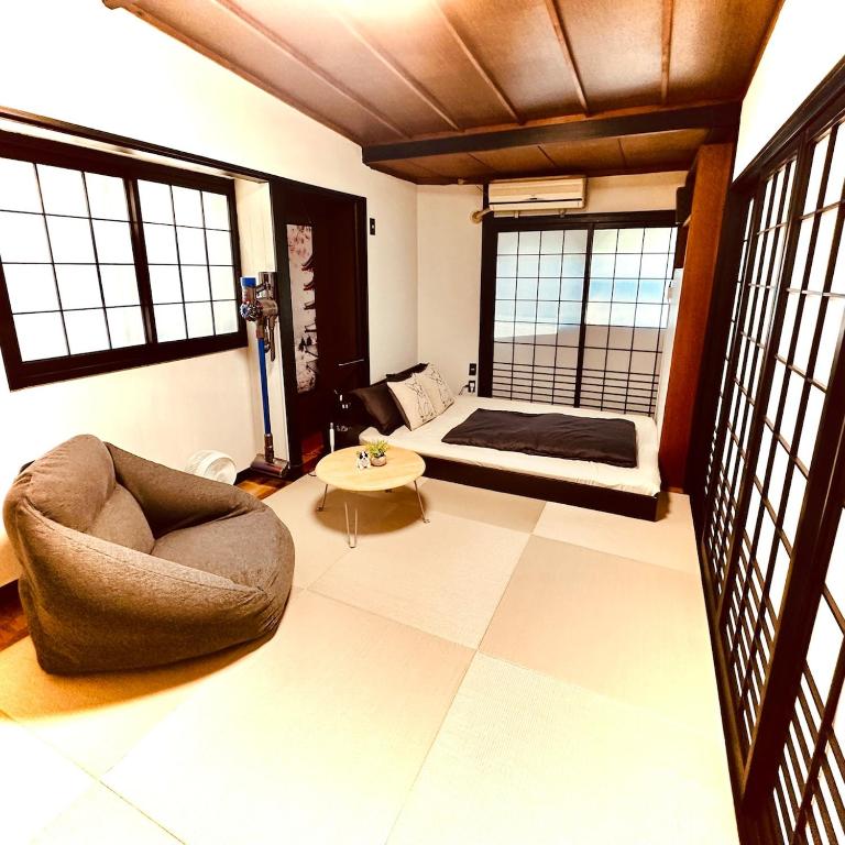 a living room with a couch and a bed at Between Kyoto & Osaka 渚西 駅徒歩6分 in Hirakata