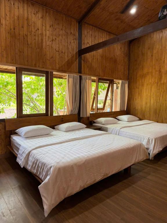three beds in a room with wooden walls and windows at Xóm Sình Homestay & Farmstay Buôn Ma Thuột ĐakLak in Ðat Lý (1)