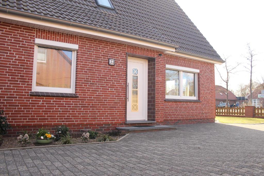 a red brick house with a white door at Ferienwohnung "Groote Koje" in Barßel