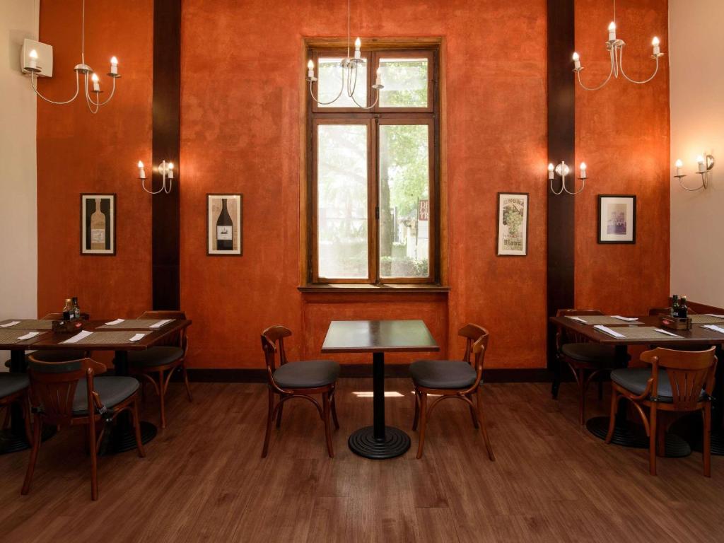 a restaurant with tables and chairs and a window at ibis Curitiba Batel in Curitiba