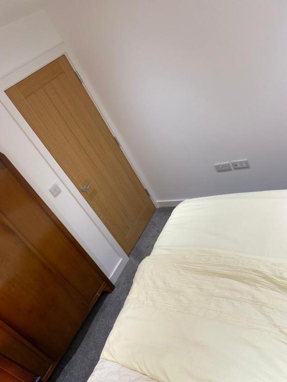 a bedroom with a bed and a wooden dresser at Have a fun and rest in Hull