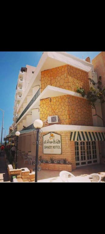 a building with a sign on the side of it at New Sandy Hotel in Marsa Matruh