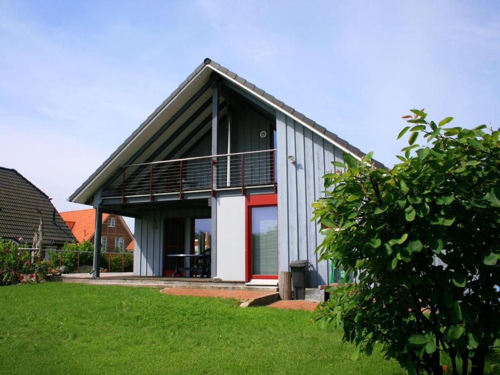 a house with a red door and a balcony at Seestrasse 35 in Insel Poel