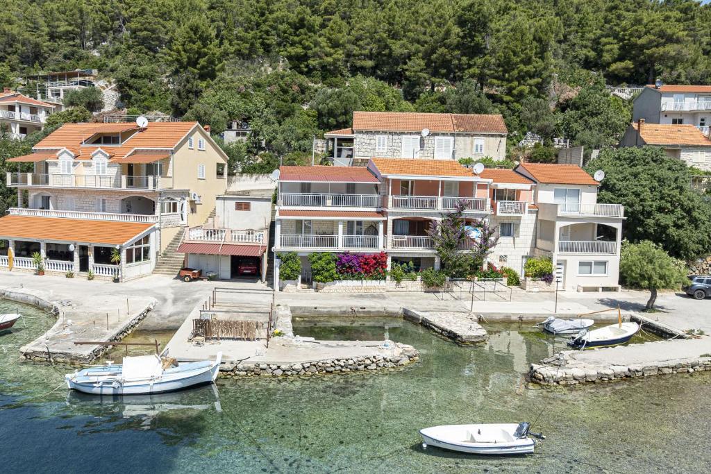 a group of houses and boats in a body of water at Apartments by the sea Grscica, Korcula - 169 in Prizba