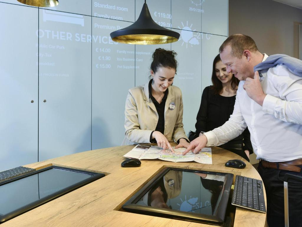 a group of people standing around a table with a computer at ibis Kortrijk Centrum in Kortrijk