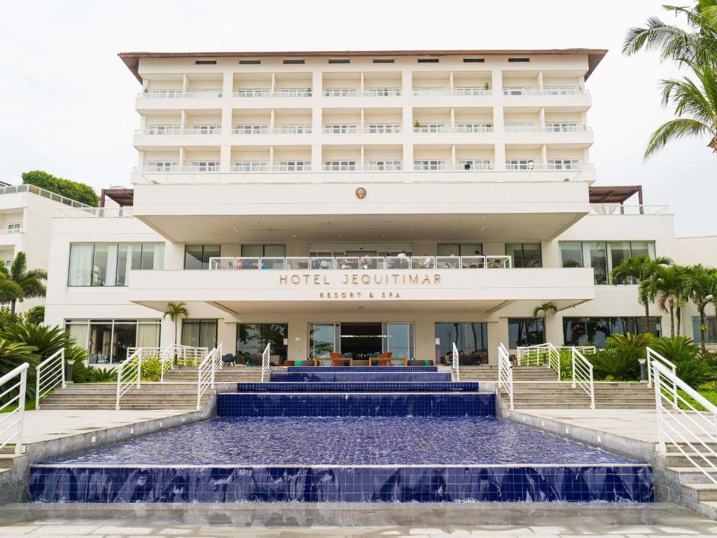 a hotel building with blue stairs in front of it at Hotel Jequitimar Guaruja Resort & Spa by Accor in Guarujá