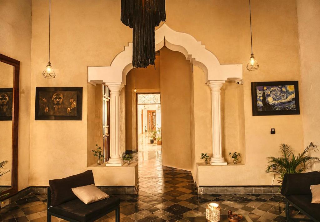 a lobby with chairs and paintings on the walls at Hotel Boutique Casa Jade in Campeche
