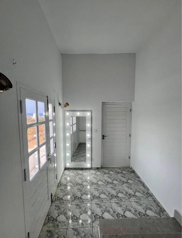 a hallway with a door and a tile floor at Maison vue mer in Rafrāf