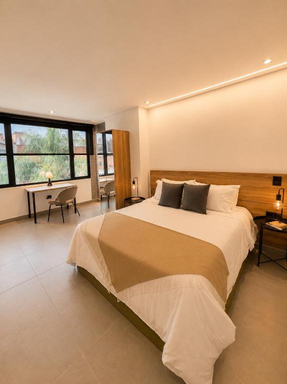 a large bedroom with a large bed and a desk at Once Suites in Envigado