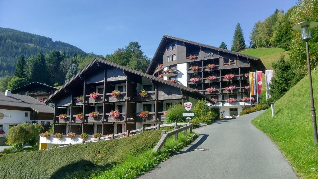 a building on a hill with flowers on the windows at Alpenlandhof in Bad Kleinkirchheim