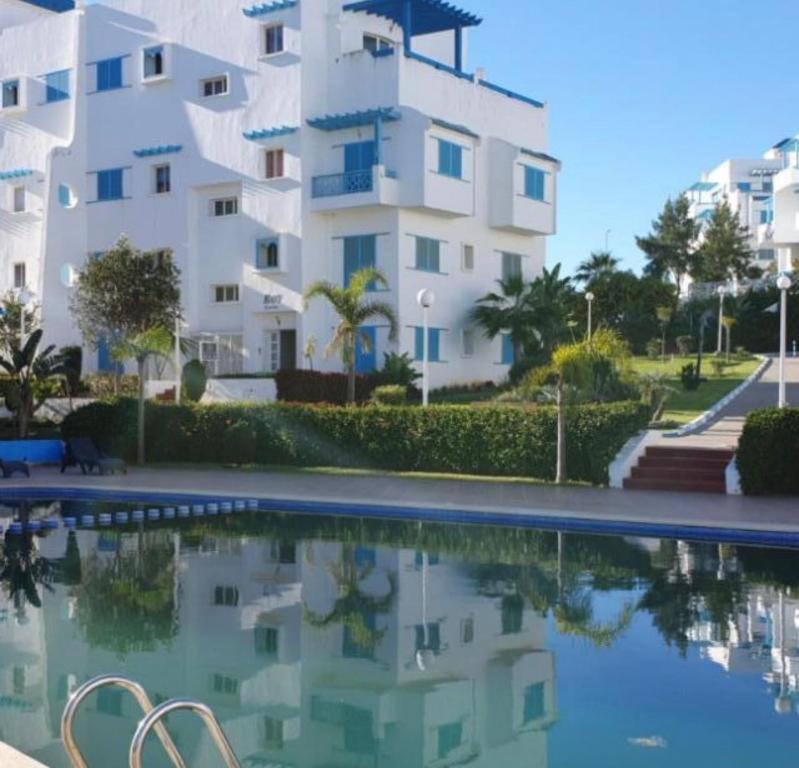 a building with a swimming pool in front of a building at Cozy appartement smir park in Tétouan