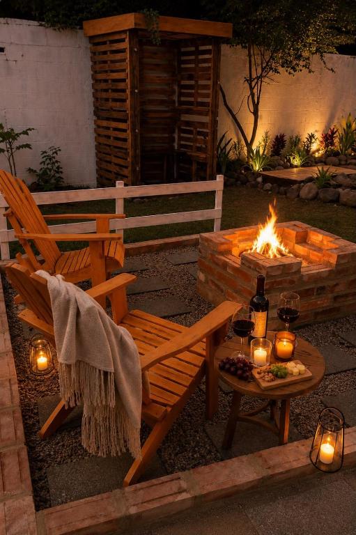 a fire pit with a bench and a table with candles at Refúgio Casinha Branca in Duque de Caxias