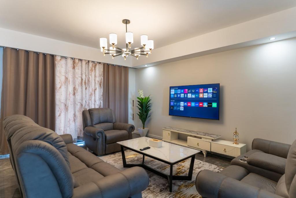 a living room with couches and a flat screen tv at Spectacular 3 bedroom apartment in Syokimau