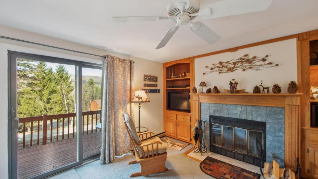 a living room with a fireplace and a balcony at Quick Silver - Summit at Gore Mountain by AvantStay in North Creek