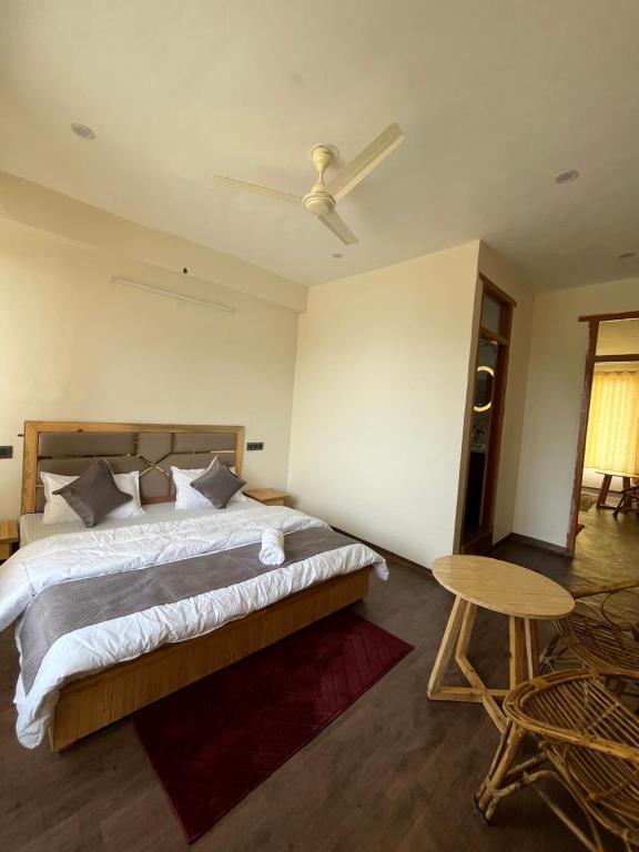 a bedroom with a large bed and a table at Sunset Lagoon Dalhousie in Dalhousie