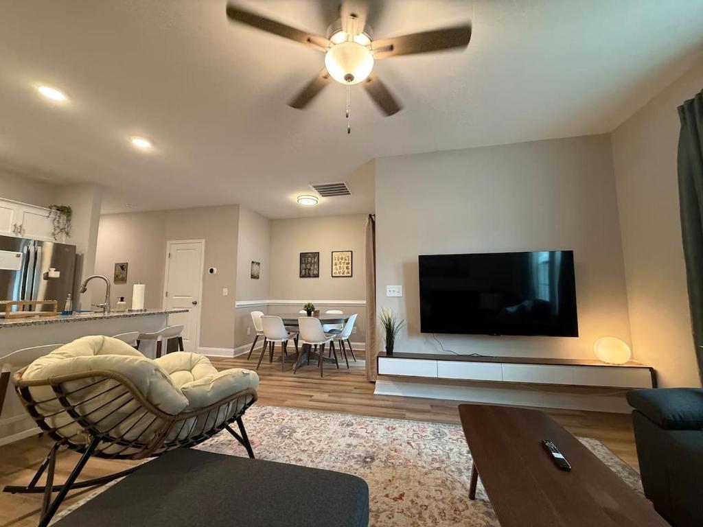 a living room with a ceiling fan and a flat screen tv at Tide's Turn Retreat in Cedar Point