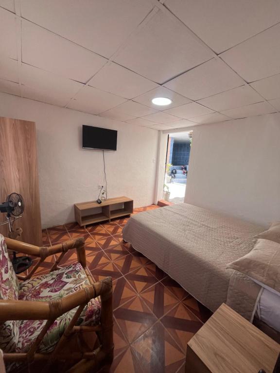 a bedroom with a bed and a tv and a chair at Alojamiento Mujer Dormida in Ambuquí