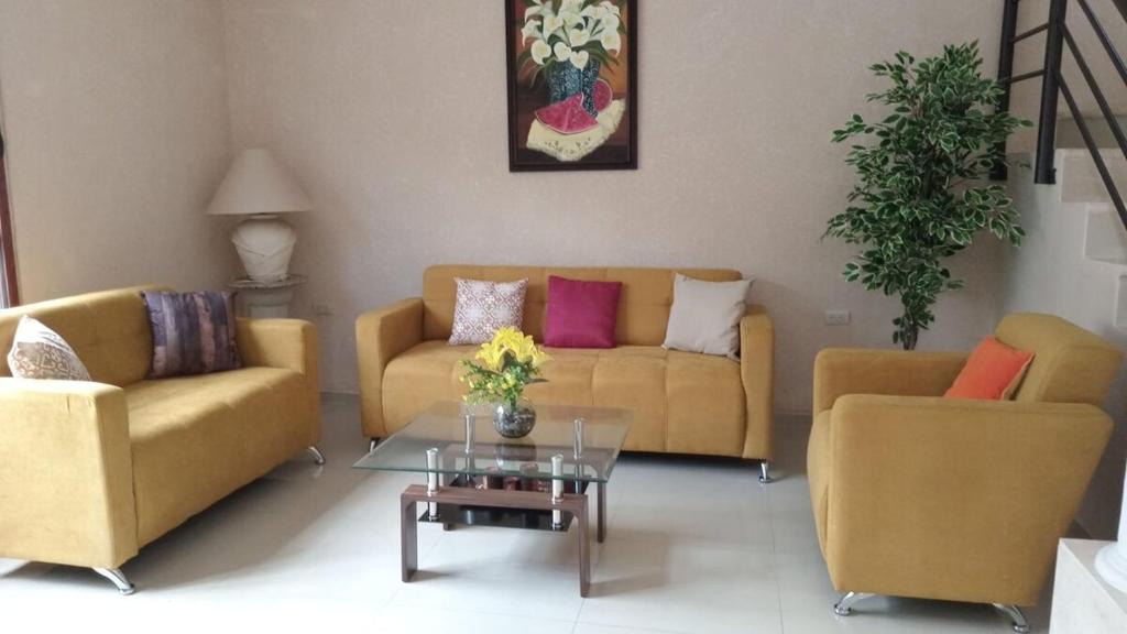 a living room with two couches and a table at Gated house with garden and pool Mérida in Caucel