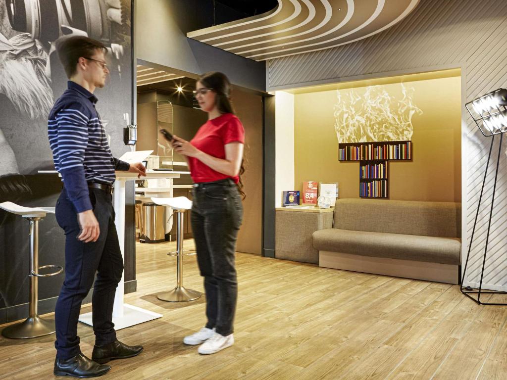 a man and a woman standing in a store at Ibis Styles Paris Massena Olympiades in Paris