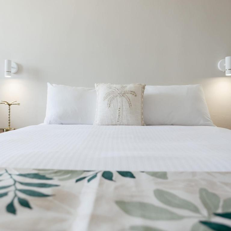 a white bed with white sheets and pillows at Tocumwal Hotel Motel in Tocumwal