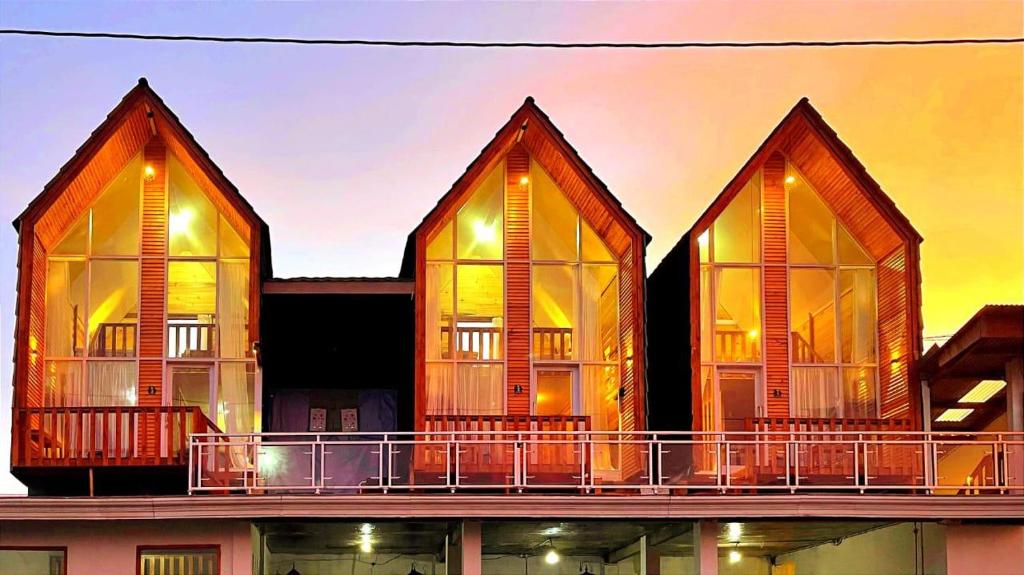 a building with large windows on top of it at Villa Celyn Dieng cabin in Diyeng