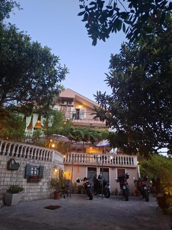 a building with motorcycles parked in front of it at Apartmani Paulino in Herceg-Novi