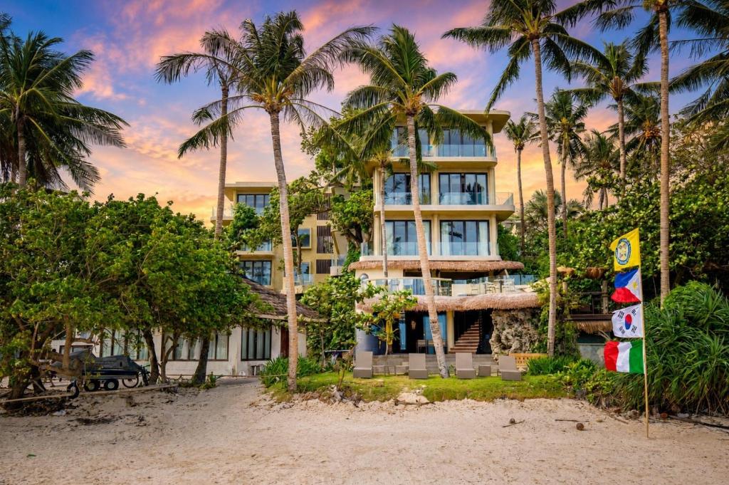 a building on the beach with palm trees at Encantada Residences in Boracay