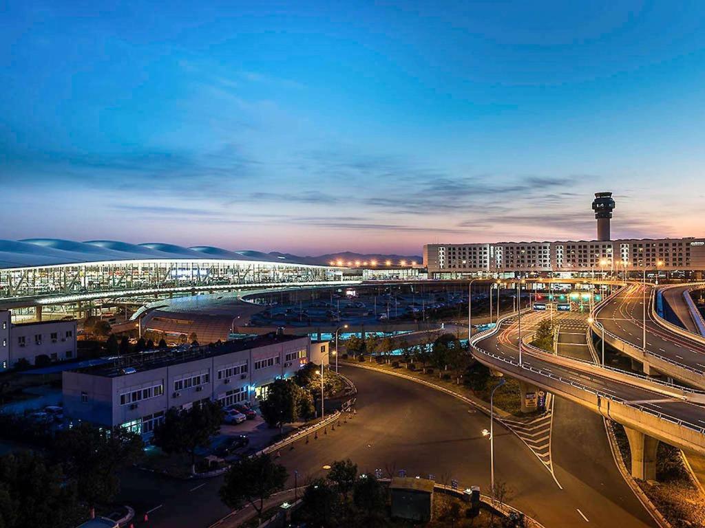 a city with a bridge over a street at night at Pullman Nanjing Lukou Airport in Nanjing