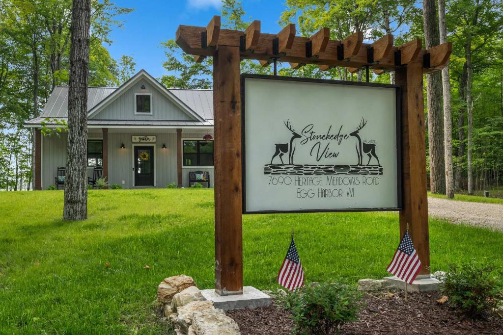 a sign in front of a house with two american flags at Stonehedge View by Simple Life Rentals in Egg Harbor