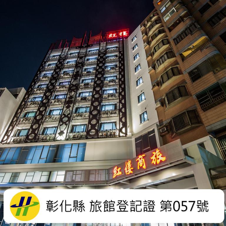 a tall building with a sign in front of it at Red hotel in Yuanlin