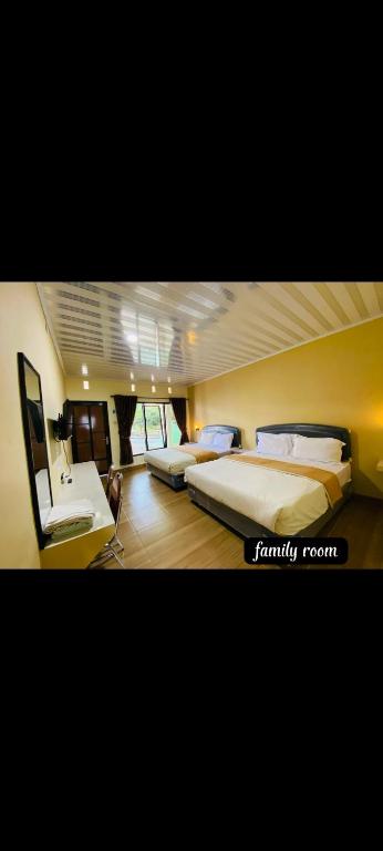 a bedroom with two beds and a desk in it at Griya Imafa Inn Batu in Tlekung