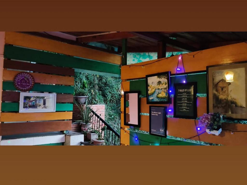 a wall with pictures and lights on it at The Moon Light Home stay in Bhīm Tāl