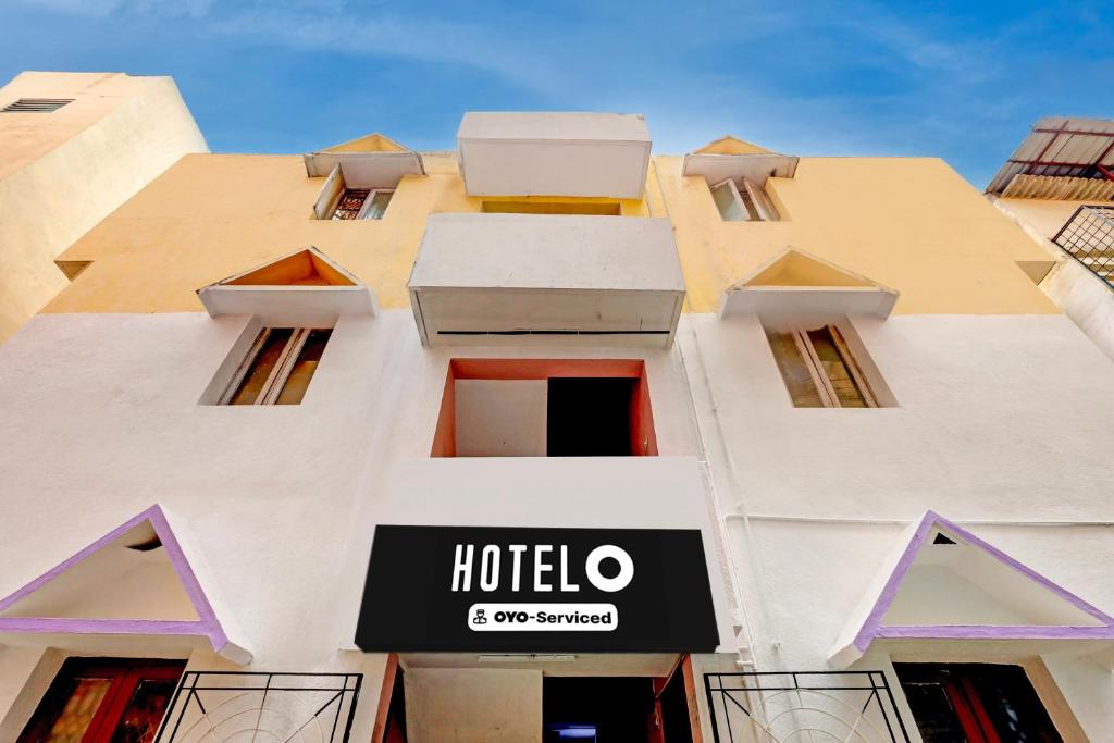 a tall white building with a hotel sign on it at Hotel O Parthasarathyswamy Temple Formerly RKH Inn in Chennai