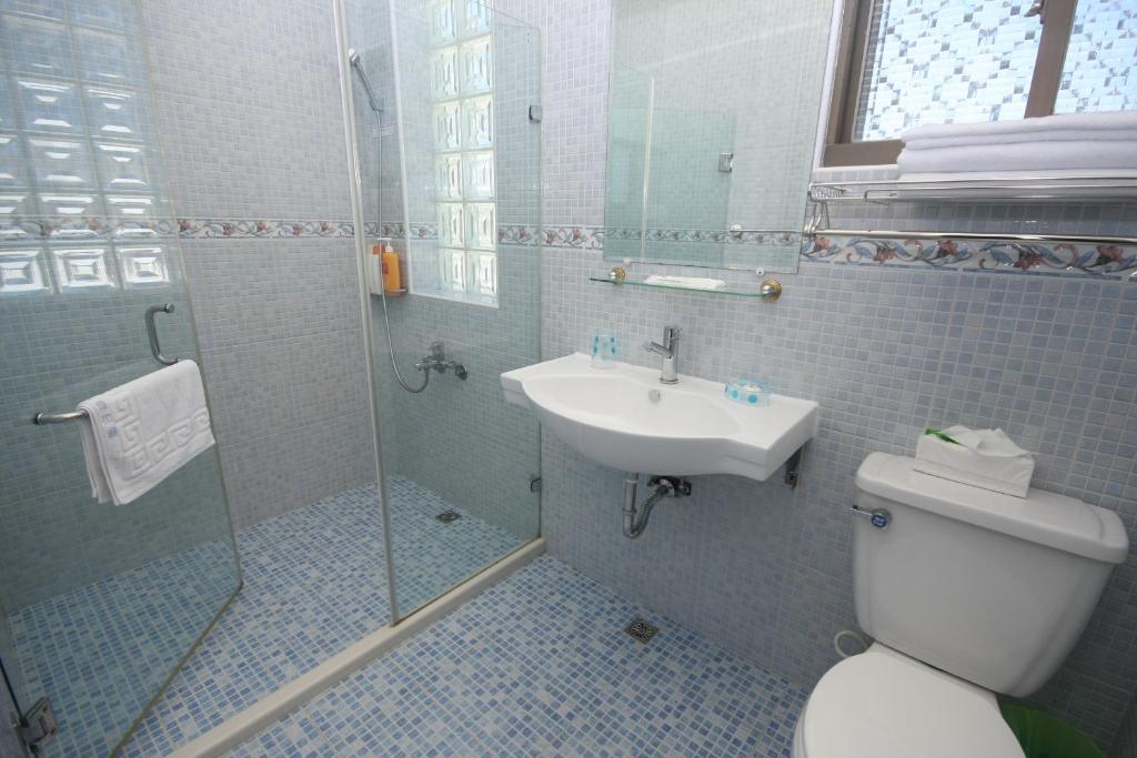 a bathroom with a shower and a toilet and a sink at Sunrise B&amp;B in Huxi