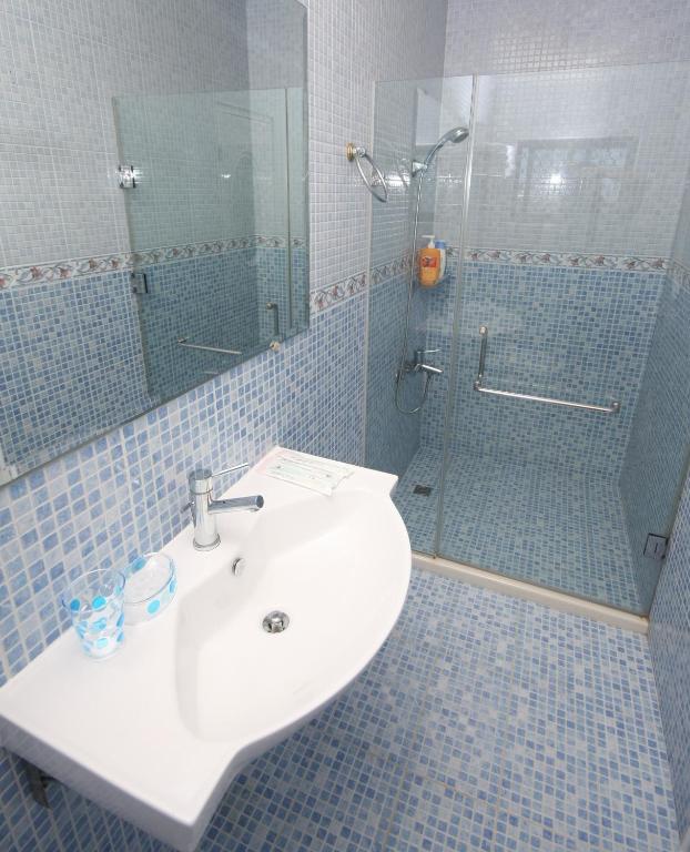 a bathroom with a sink and a shower at Sunrise B&amp;B in Huxi