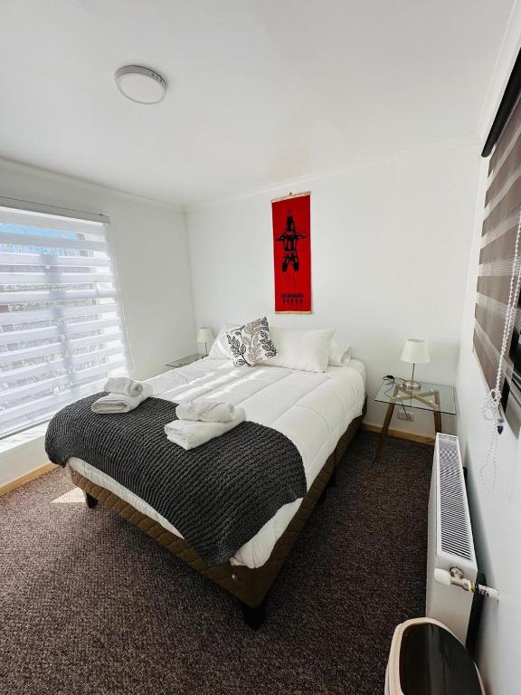 a bedroom with a large bed with a window at El Refugio in Puerto Natales