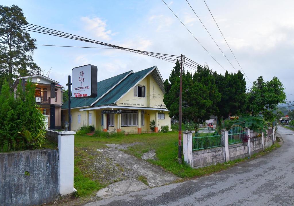 a building with a sign on the side of a street at Maya Sari Cottage Pandai Sikek in Kotabaru