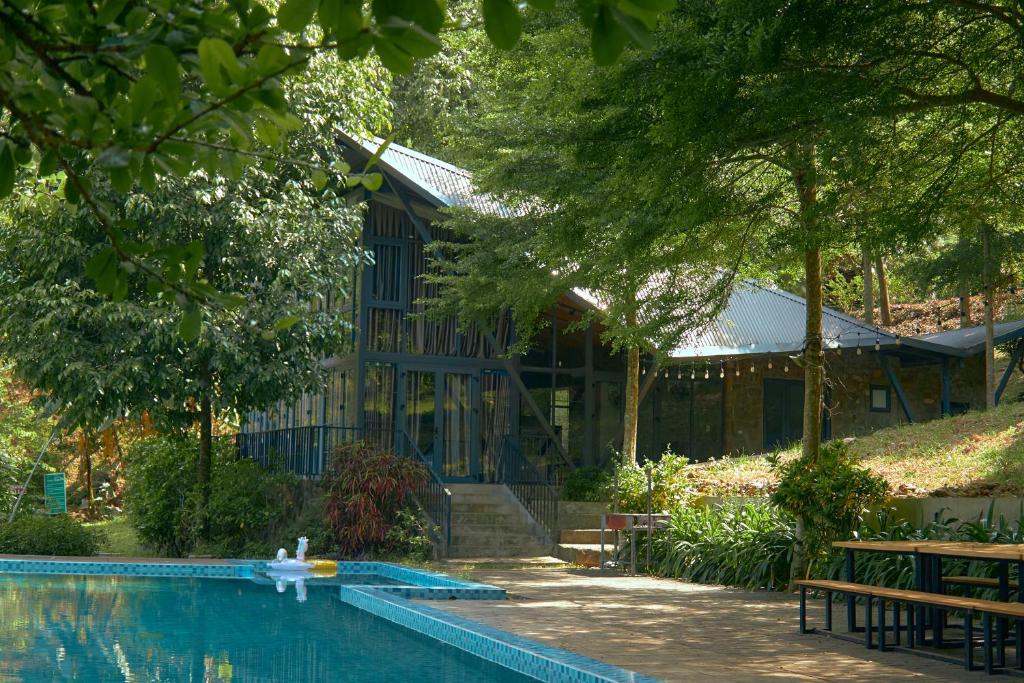 a house with a swimming pool in front of a building at Daisy Queen Village Ba Vì in Yên Cư