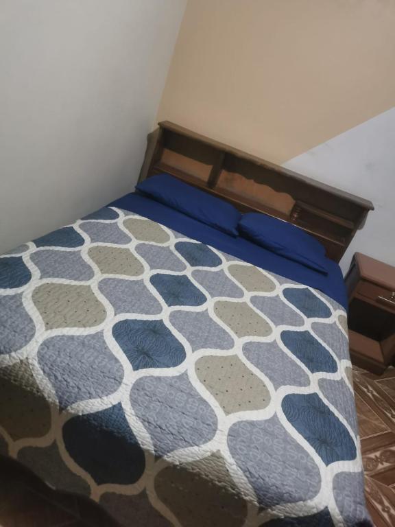 a bedroom with a bed with a blue and white bedspread at Hostal Salome in Cochabamba