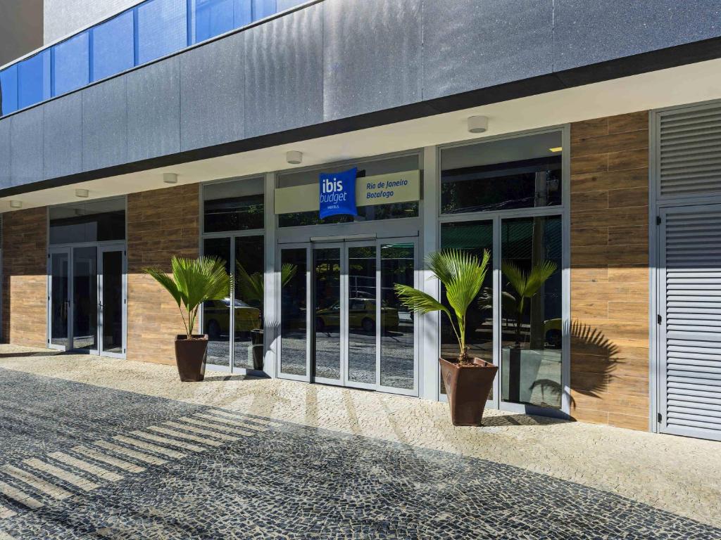 a building with two potted plants in front of it at ibis budget RJ Praia de Botafogo in Rio de Janeiro