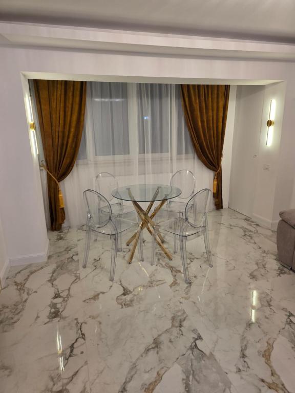 a dining room with a table and chairs on a marble floor at Sky deluxe apartment in Giurgiu