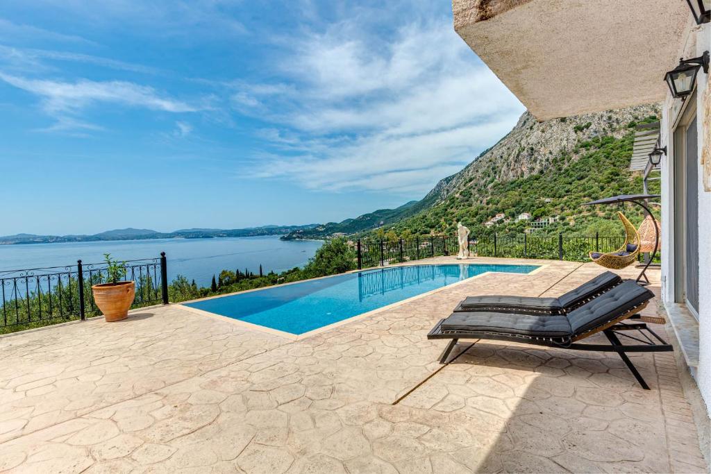 a swimming pool with a chaise lounge on a patio at Daniella with Seaview Pool in Nisaki