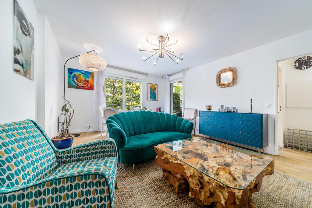 a living room with a couch and a table at Escapade du Stade BY UTA HOUSE in Saint-Denis