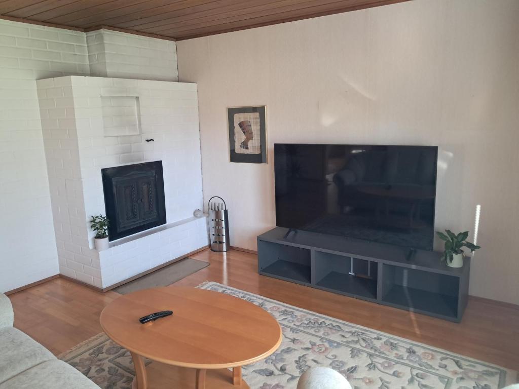 a living room with a large television and a table at Jänispolku in Rauma