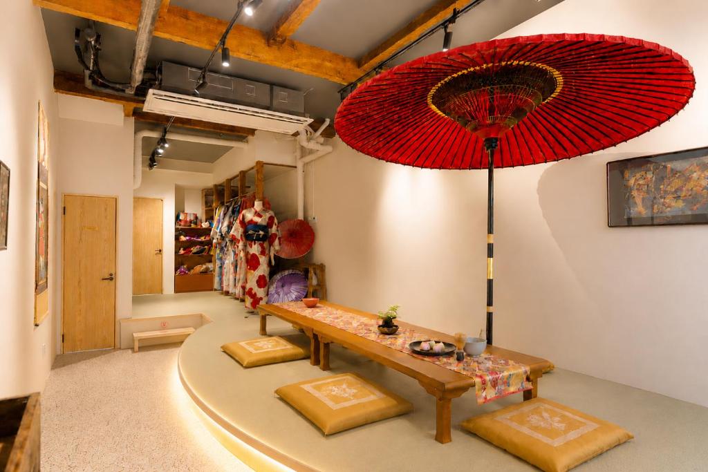 a room with a table and a red umbrella at Kimono Hotel Himeji 着物宿 in Himeji